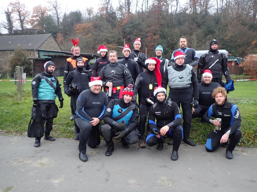 Ein Gruppenfoto von Schwimmern in Tauchanzügen mit Weihnachtsmützen